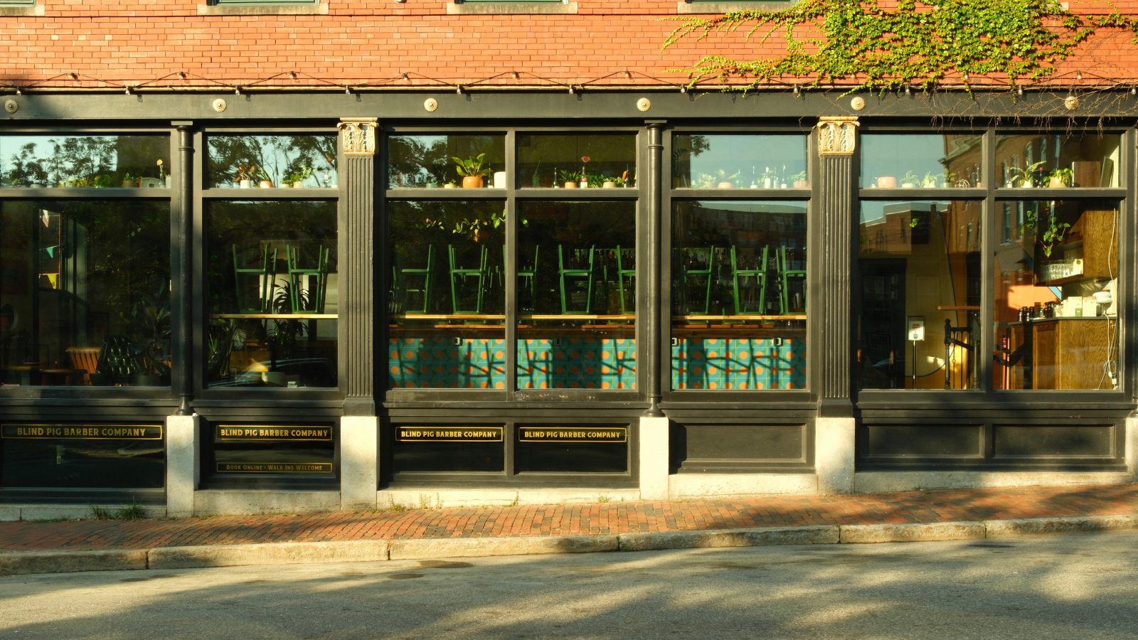 A restaurant window with green bartools