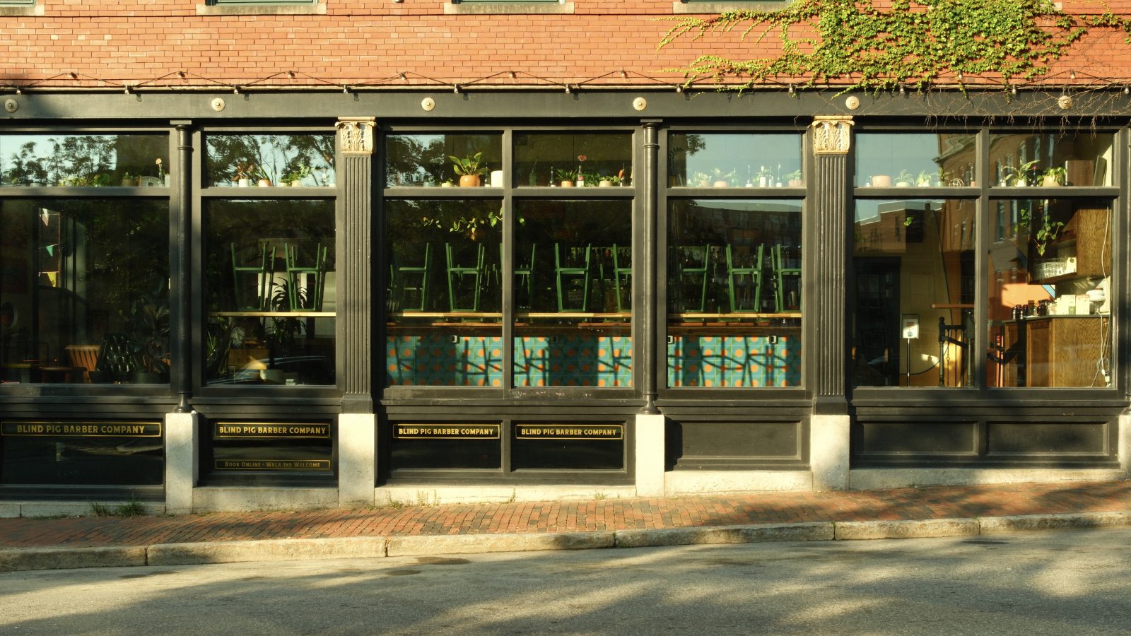A restaurant window with green bartools