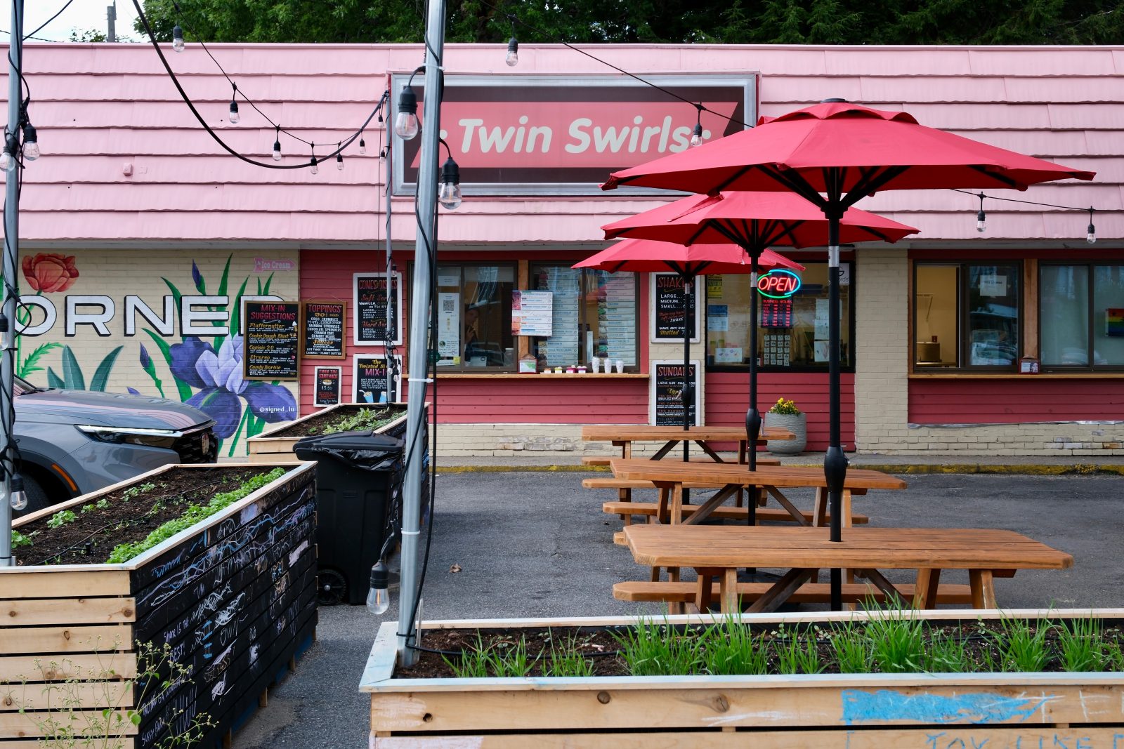 Ice cream shop with bright colors, planters, and picnic tables