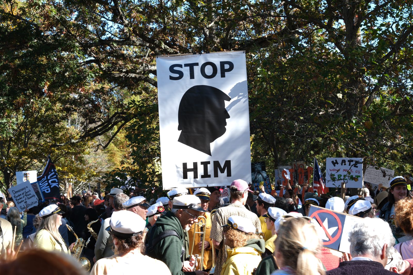 Large black and white protest sign with a silhouette of Trump