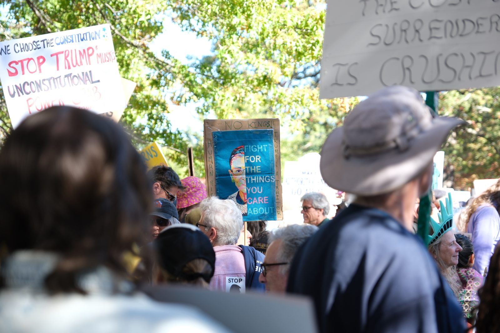 Protest sign from No Kings.  Half portrait of RBG on blue with title text
