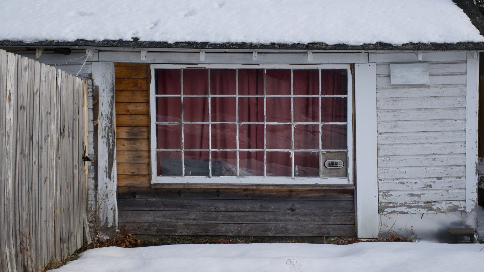 Red curtain in a slightly run down multipane window