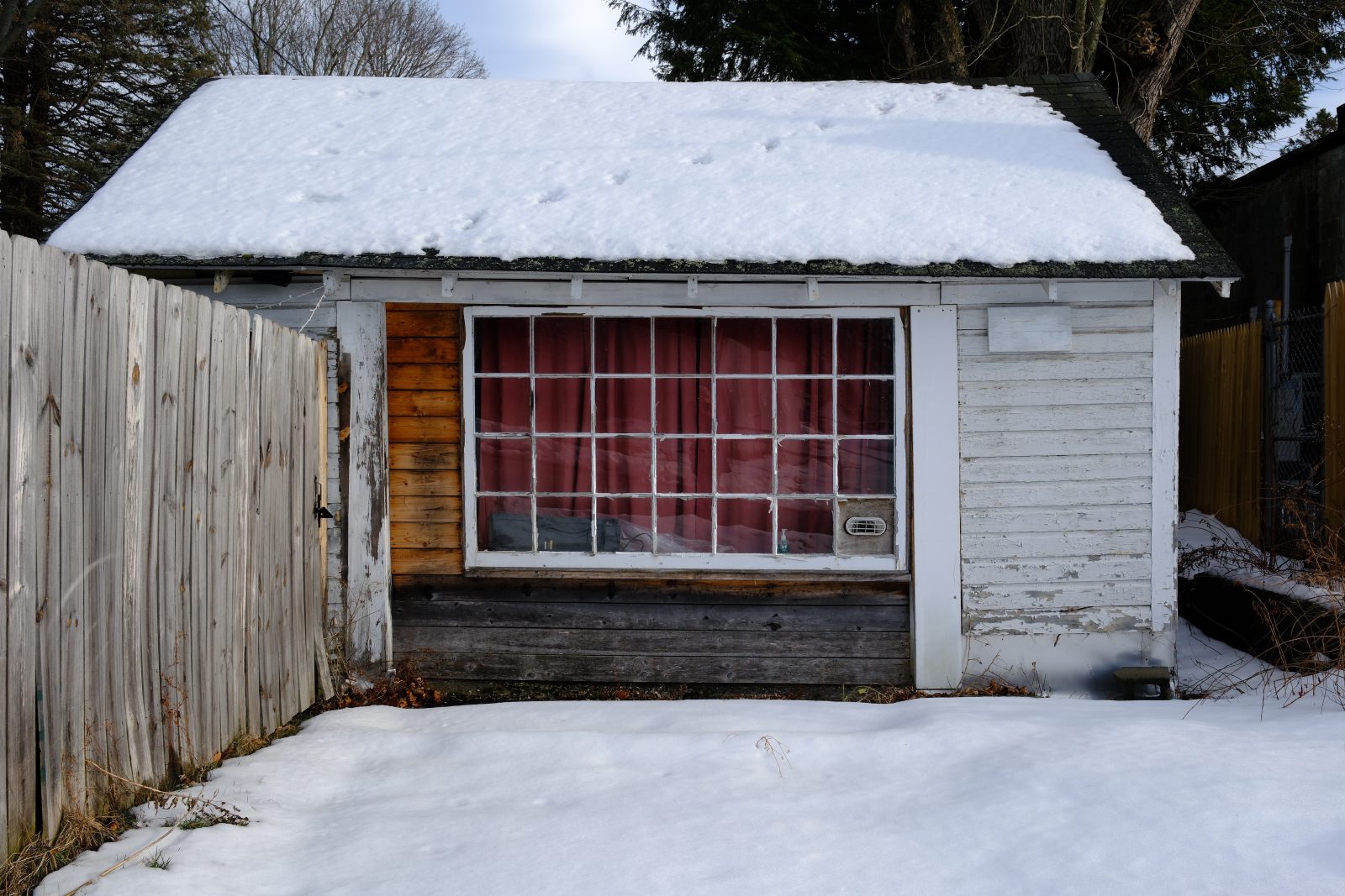 Red curtain in a slightly run down multipane window