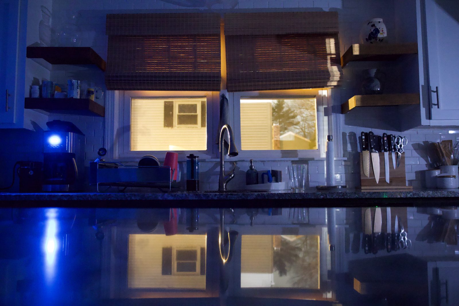 Kitchen windows letting in moonlight with a reflection in the countertop