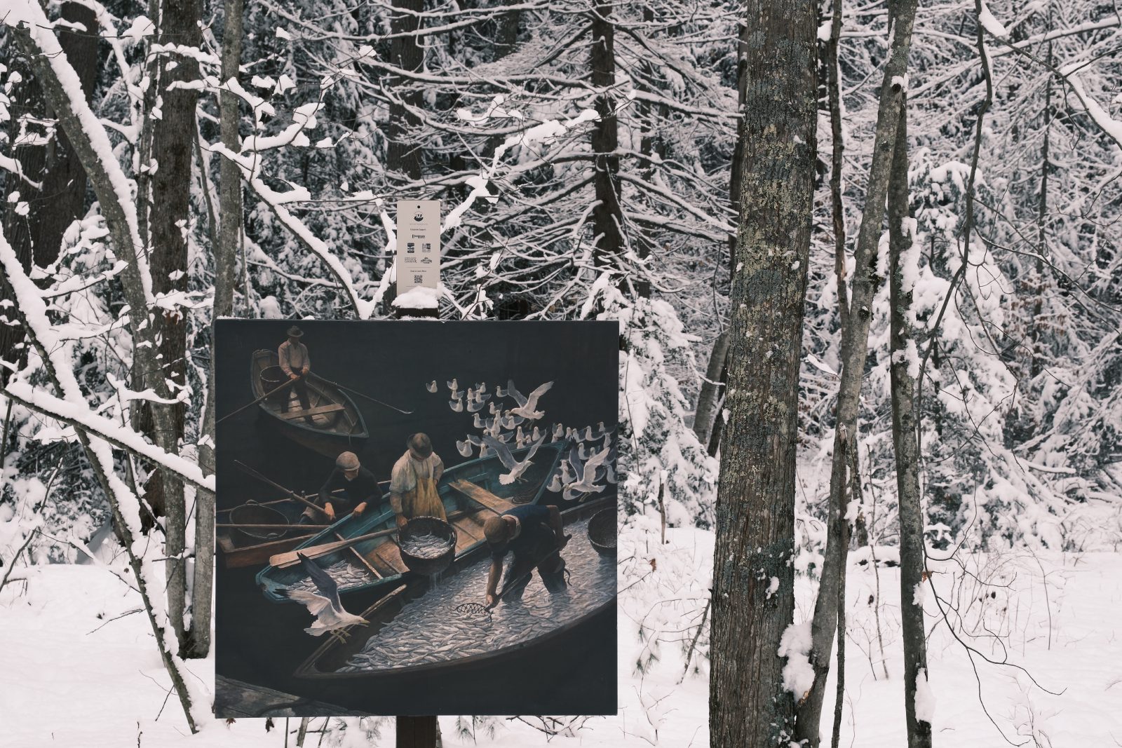 A painting hanging in the snowy woods