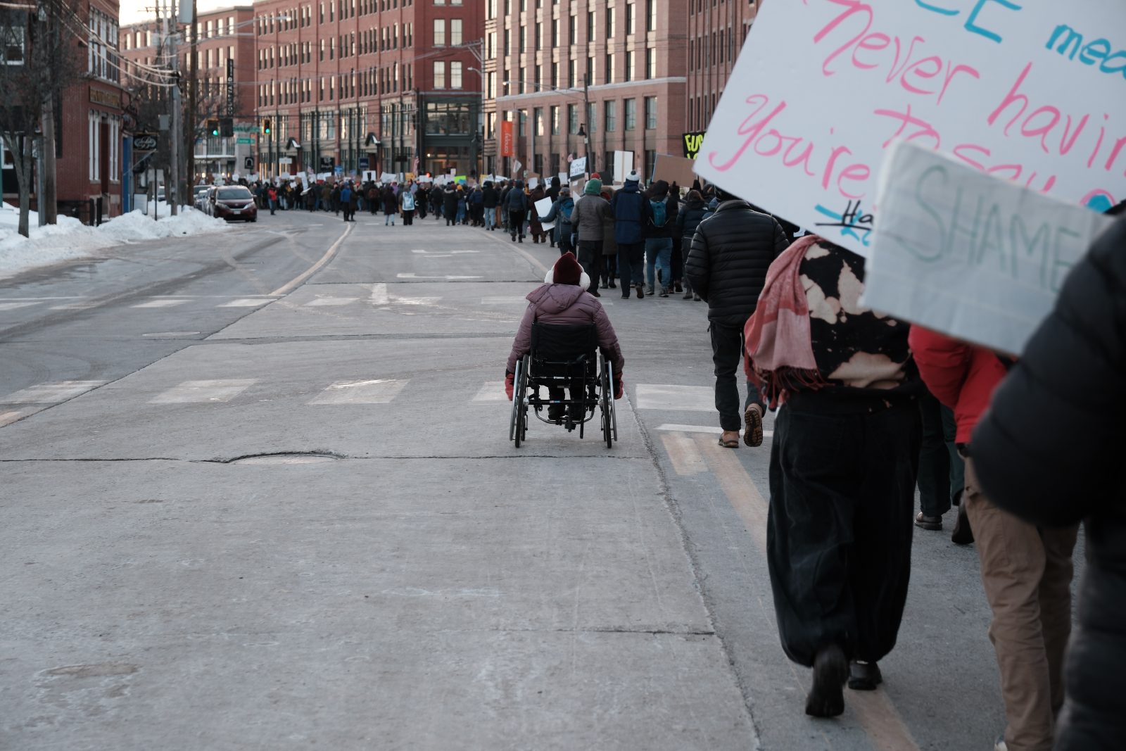 A women in a wheel chair marching along with many protestors